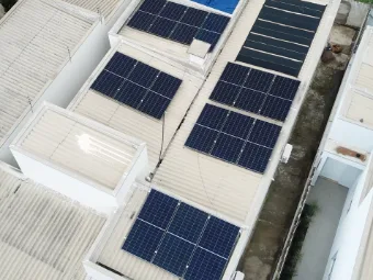 Residência vista de cima, com módulos solares aproveitando vários trechos do telhado.